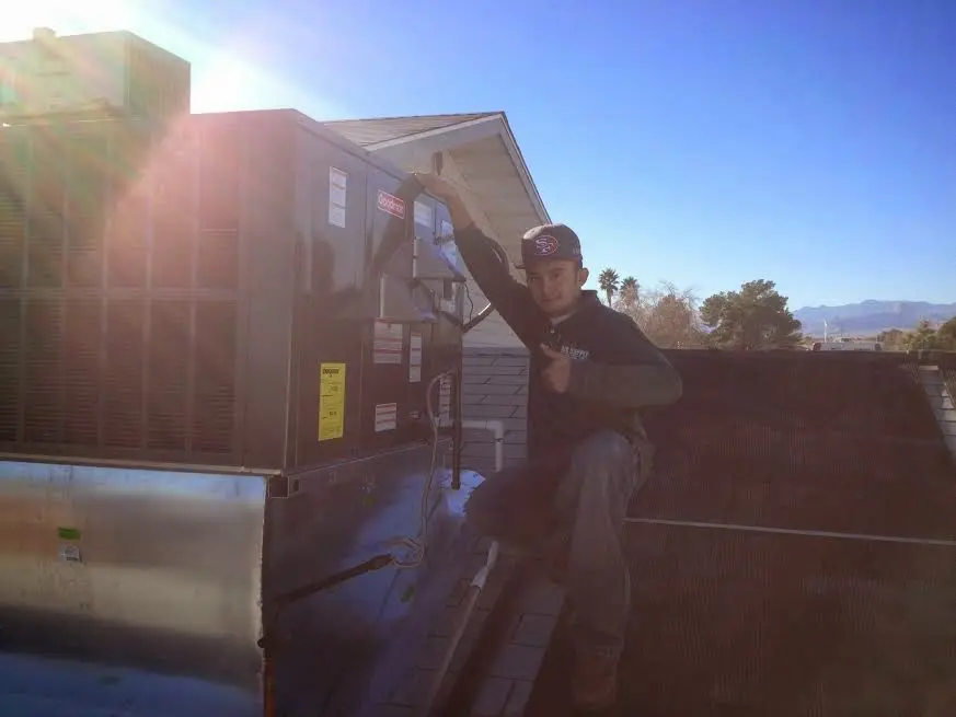 HVAC technician performing Boiler Repair on a rooftop unit in Rockingham